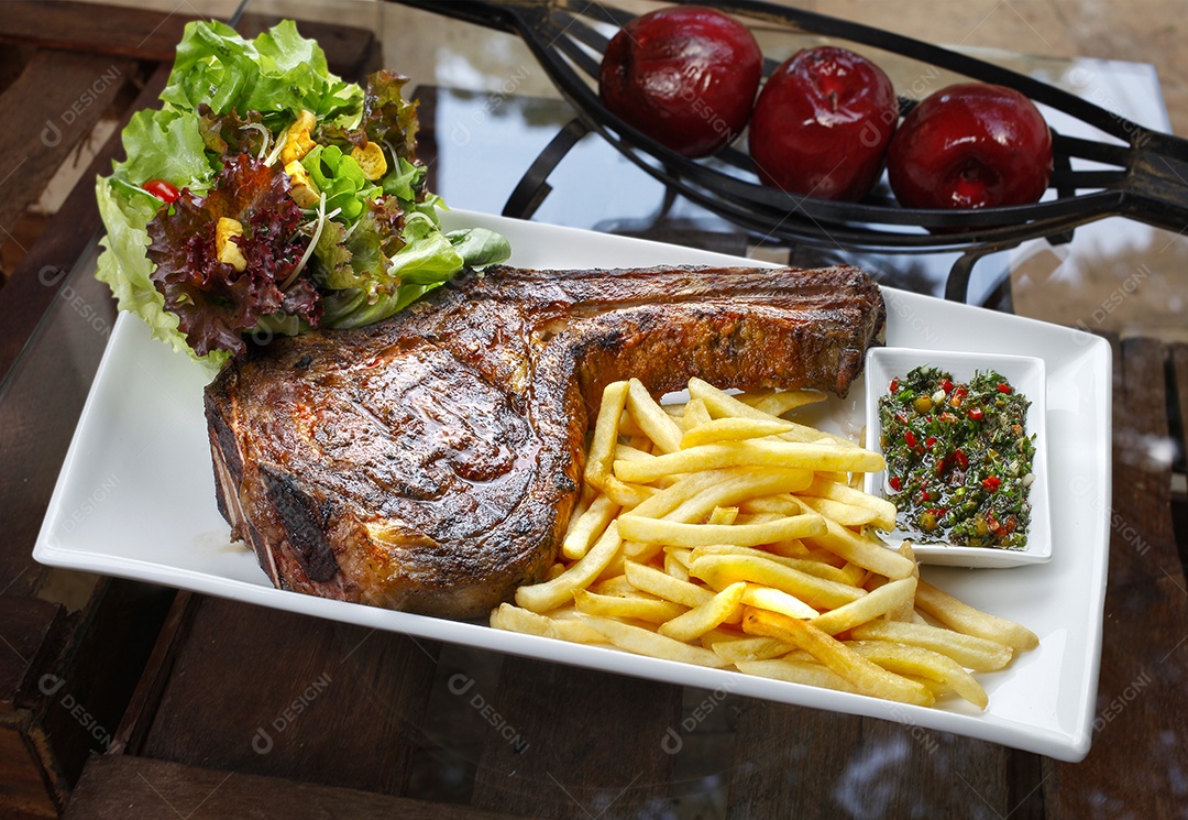 Bife tomahawk assado com batata frita e salada