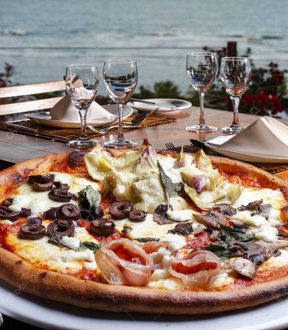 Pizza de sabores sobre a mesa de madeira com vista para o mar