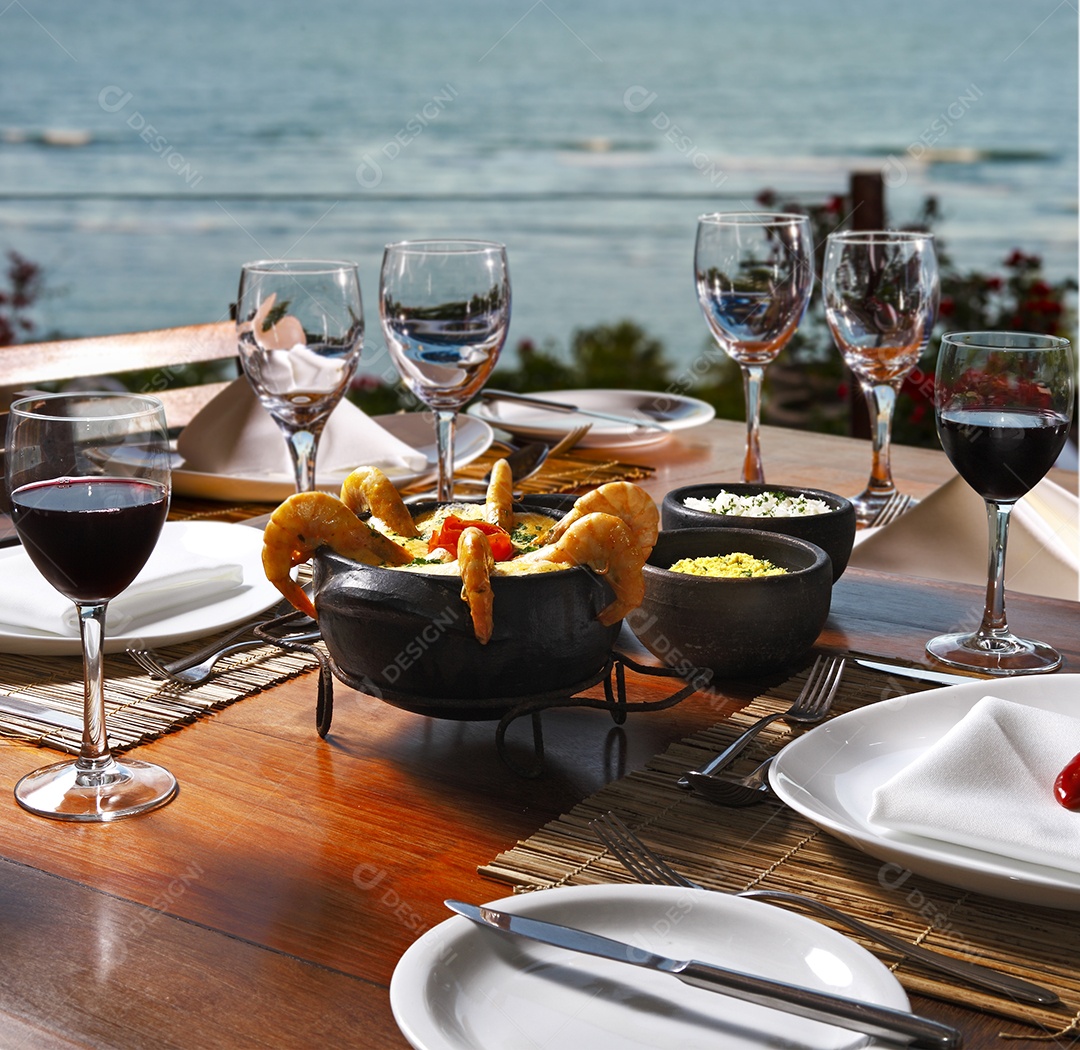 Moqueca de camarão e taças de vinho