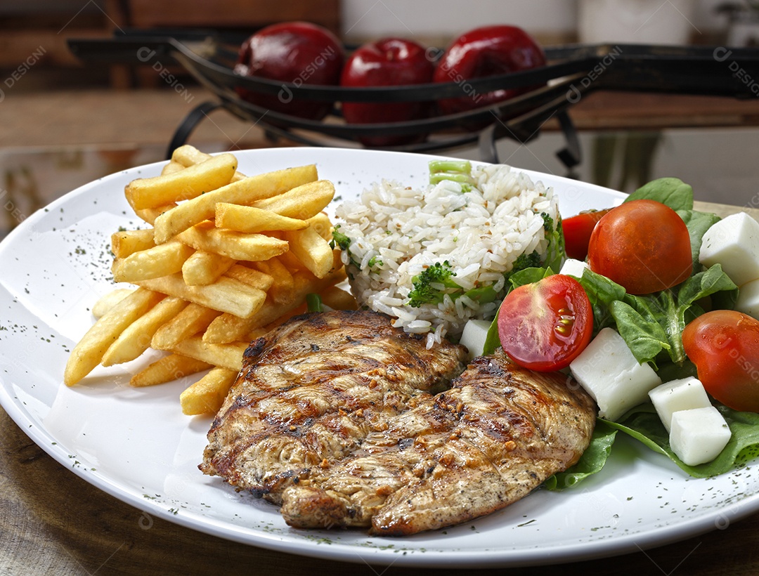 Carne de porco grelhada com salada, batatas fritas e arroz