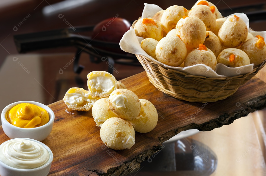 Pães de queijo com catupiry e cheddar sobre uma tabua de madeira