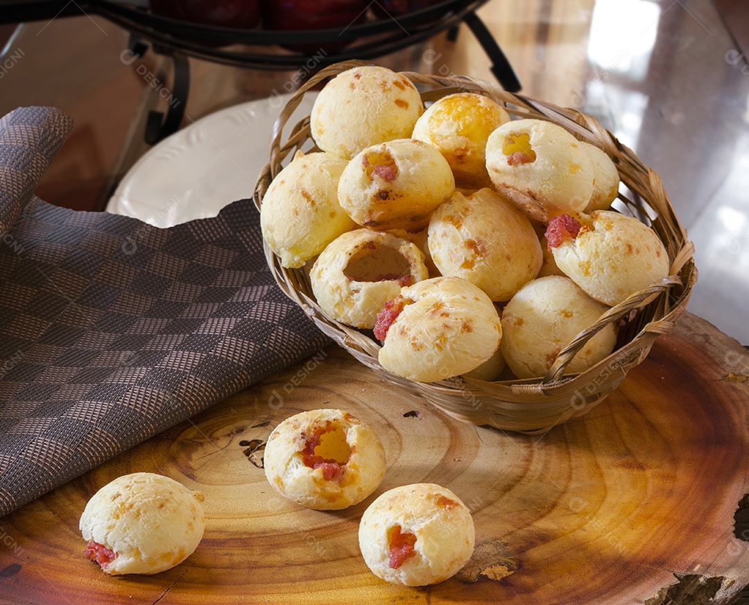 Pão de queijo com calabresa sobre mesa de madeira
