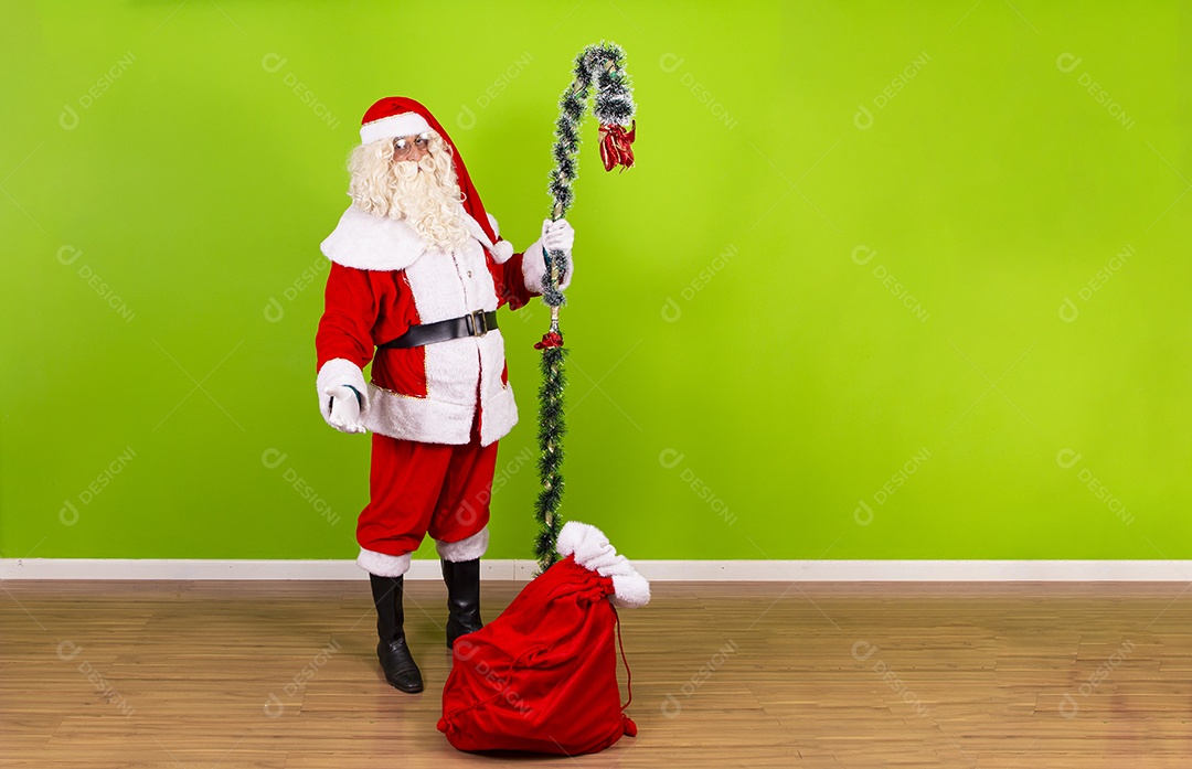 Homem vestido de Papai Noel em fundo verde