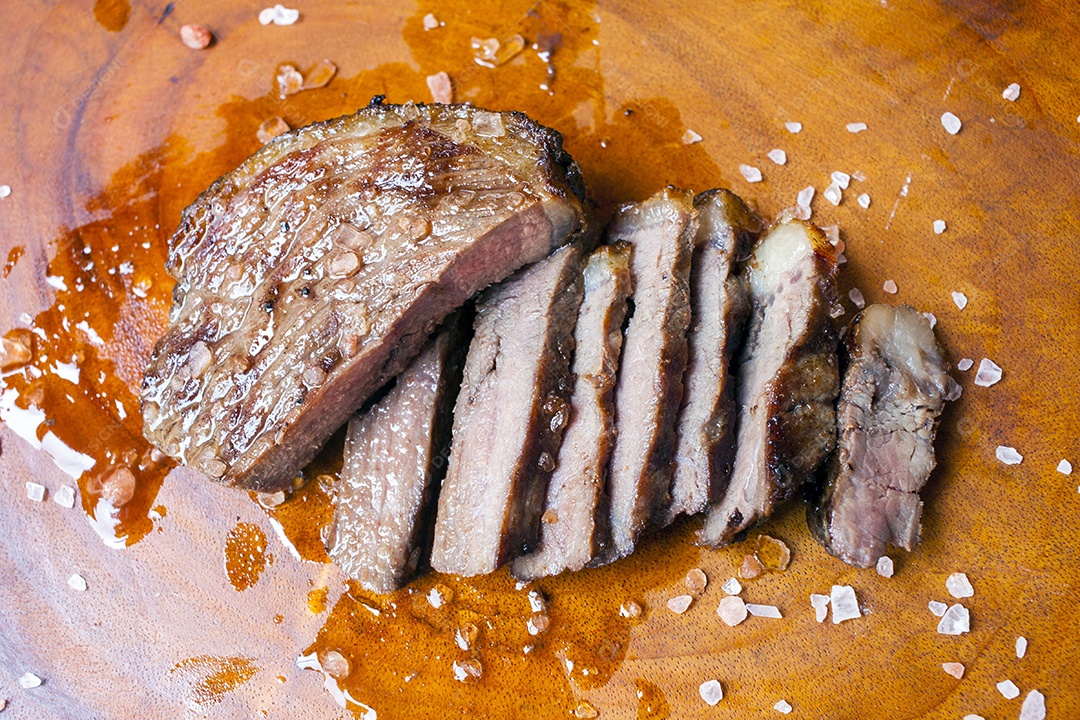 Carne assada e cortadas sobre uma tabua de madeira