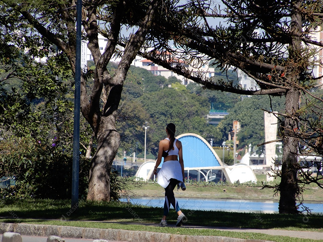 Mulher fazendo caminhada no bosque do lado da Pampulha
