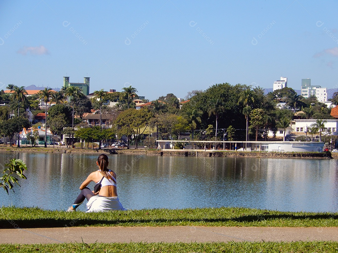 Uma mulher descansando olhando para o lago