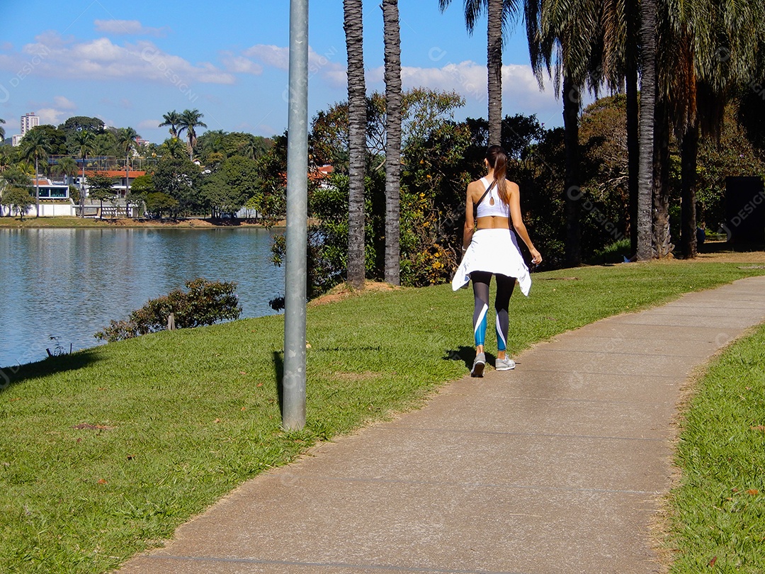 Uma jovem mulher caminhando no bosque Lagoa da Pampulha