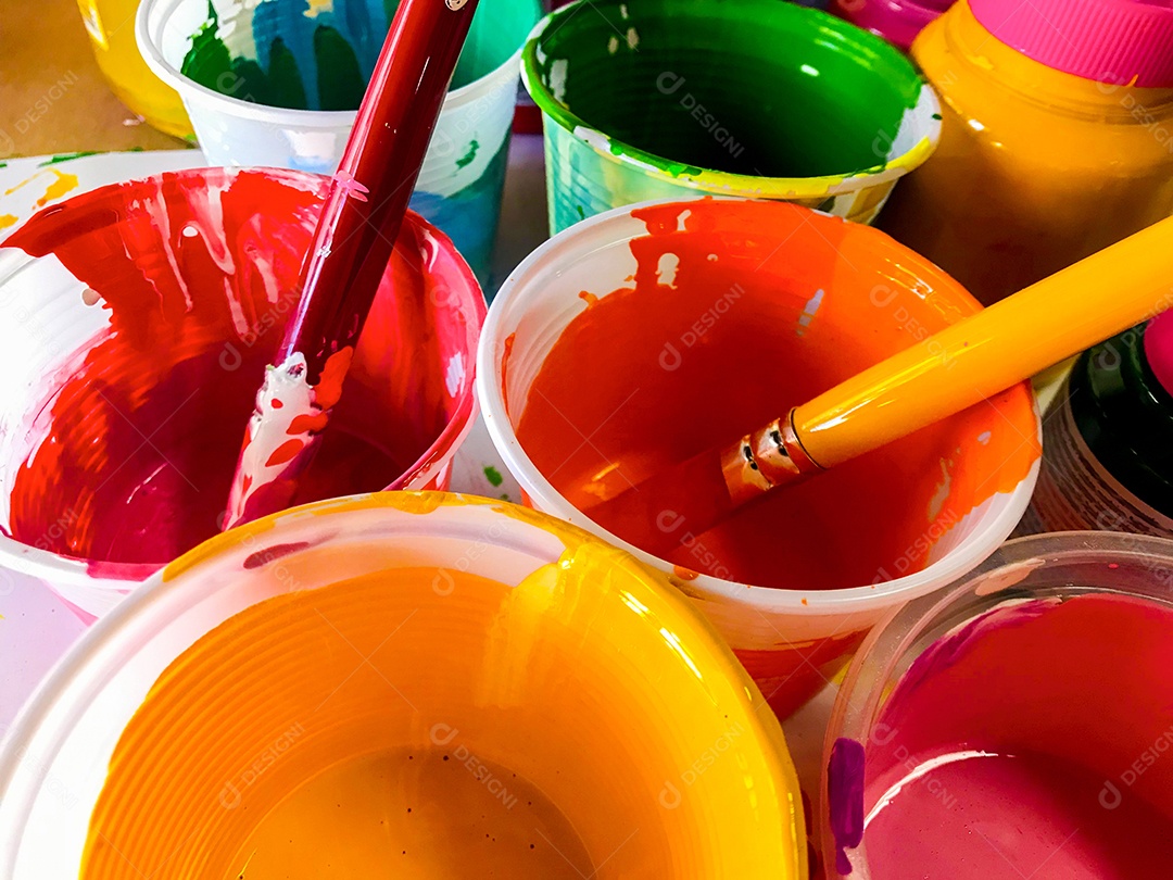 Copos com tintas coloridas e pincéis em geral