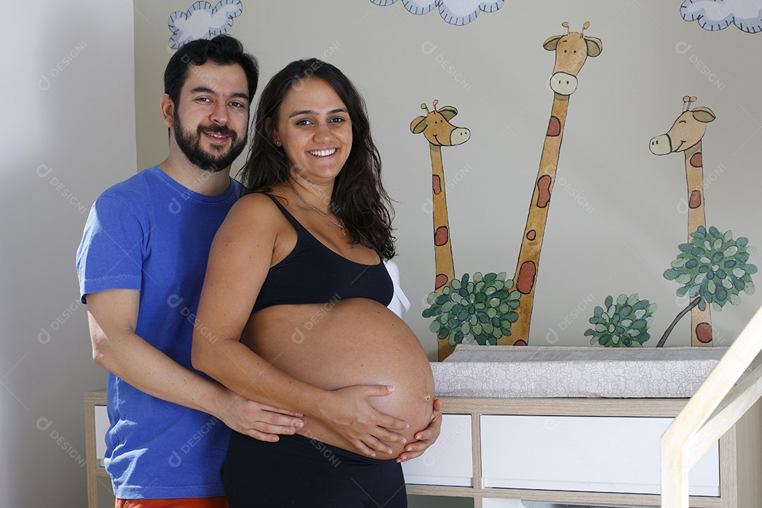 Casal feliz no quartinho do seu bebê