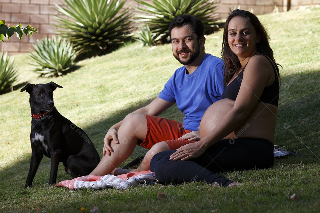 Casal com mulher gravida e seu cachorro de estimação