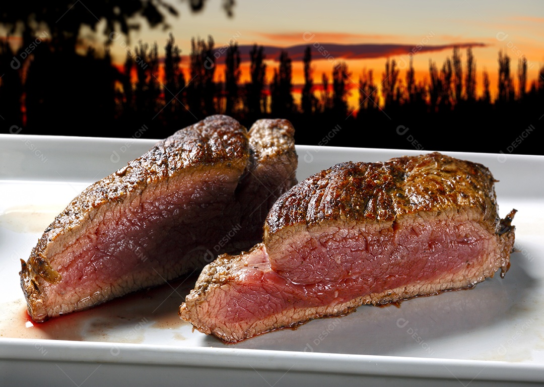 Carne ao ponto assada sobre um entardecer