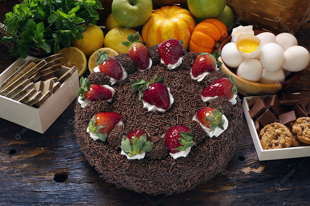 Bolo de chocolate com granulado e morangos decorando