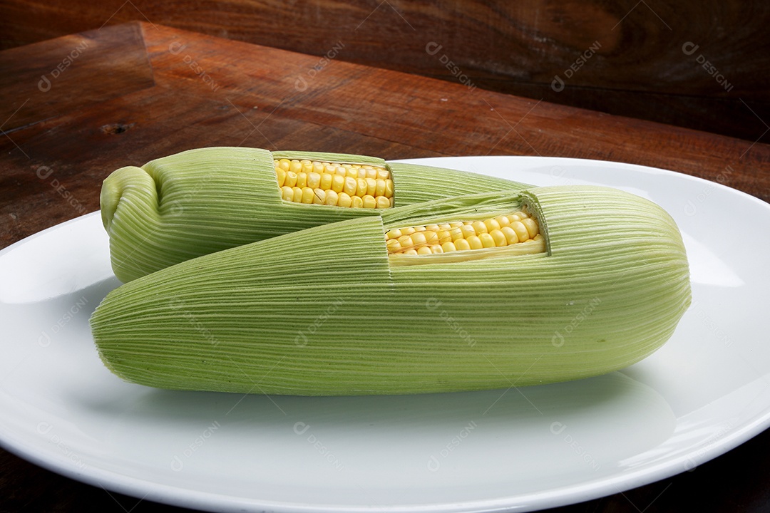 Milhos verdes sobre prato branco