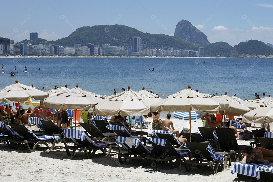 Guarda chuvas com cadeiras na beira da praia