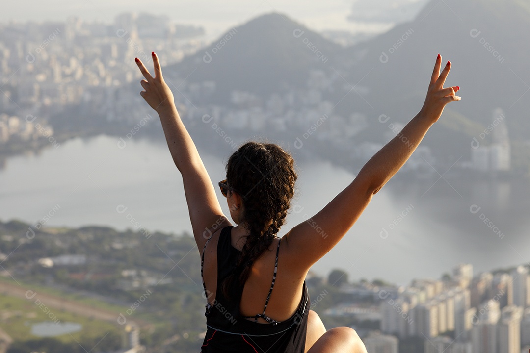 Mulher apreciando vista de montanha para mar
