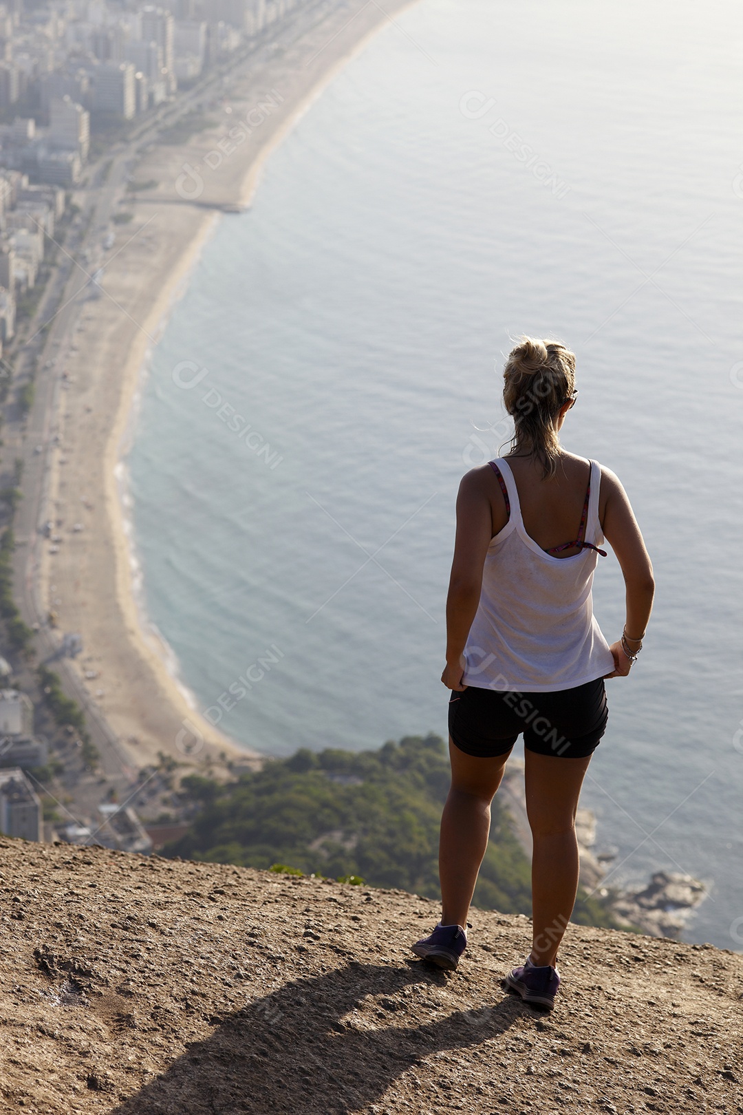 Mulher apreciando vista de montanha para mar