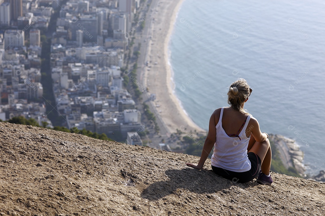 Mulher apreciando vista de montanha para mar
