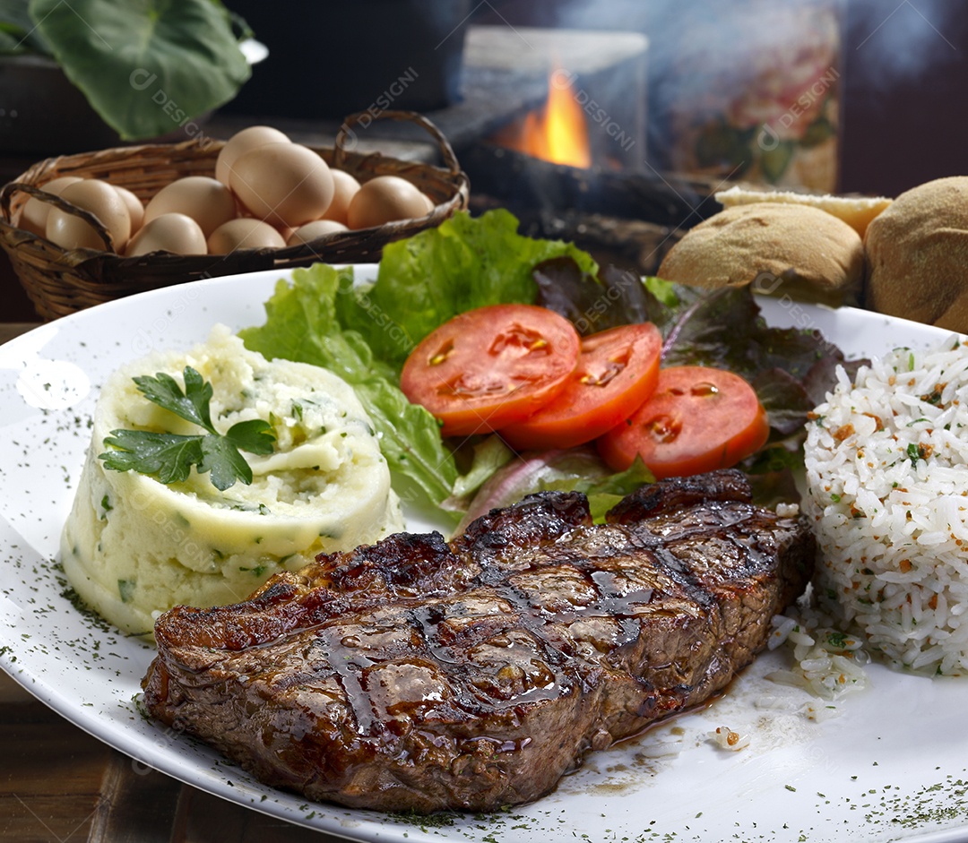 Prato com bife grelhado purê salada e arroz