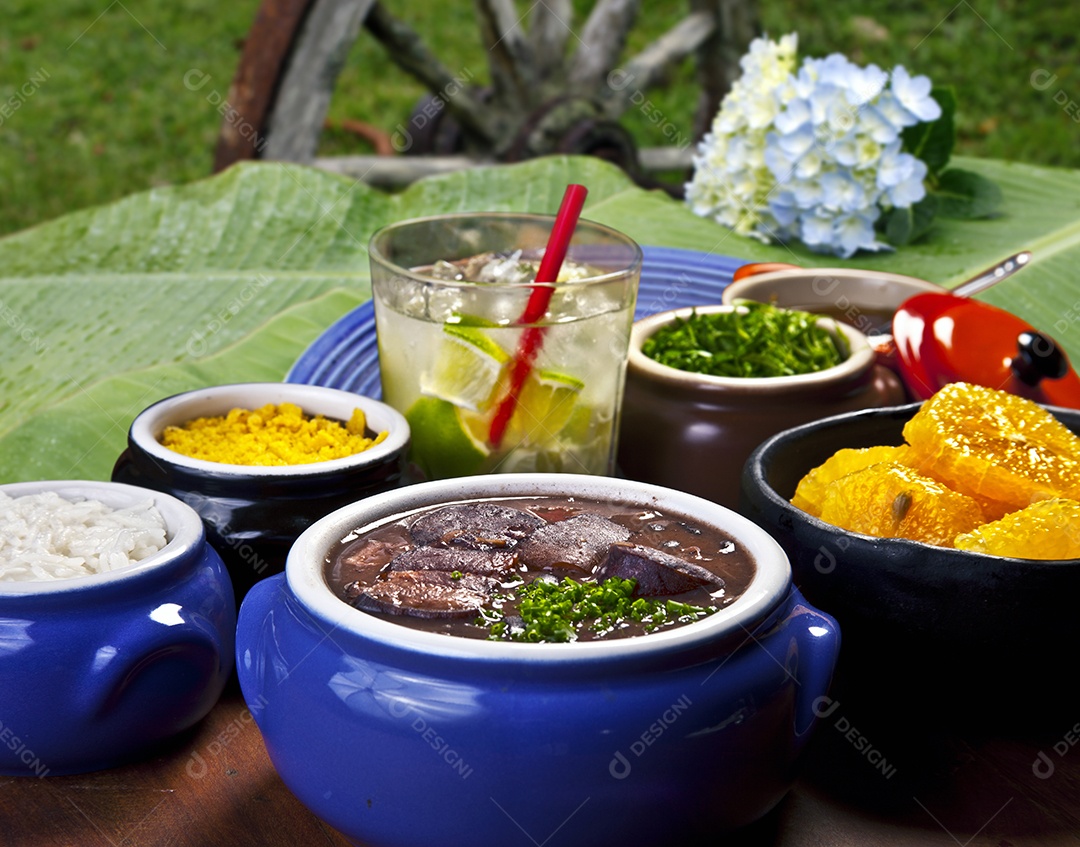 Feijoada com guarnições e caipirinha
