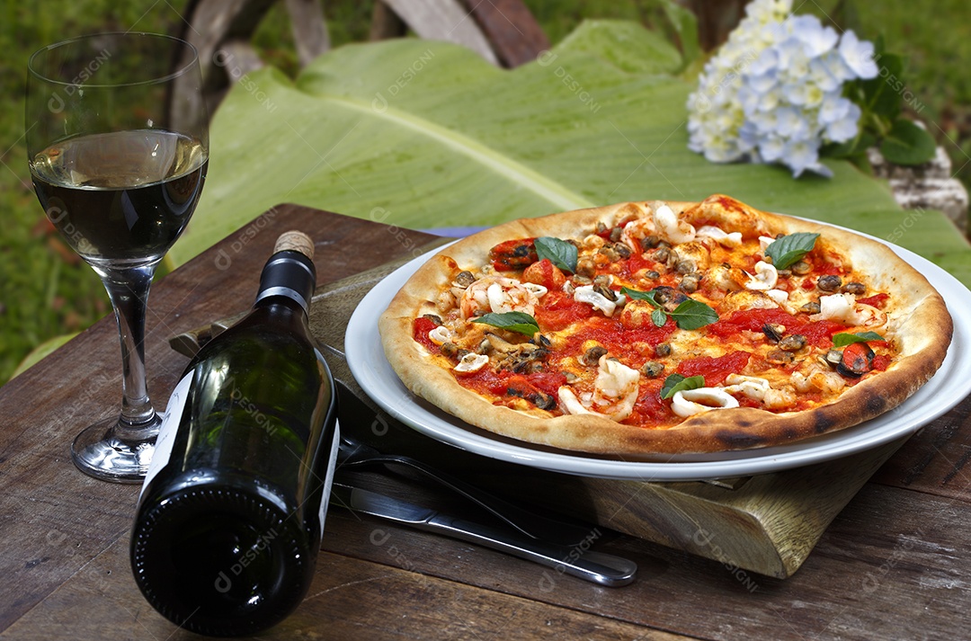 Pizza bem recheada com litro de vinho ao lado