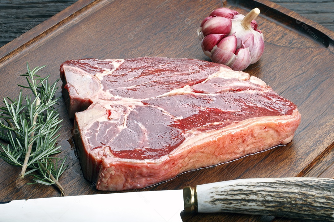 Carne crua sobre tábua de madeira