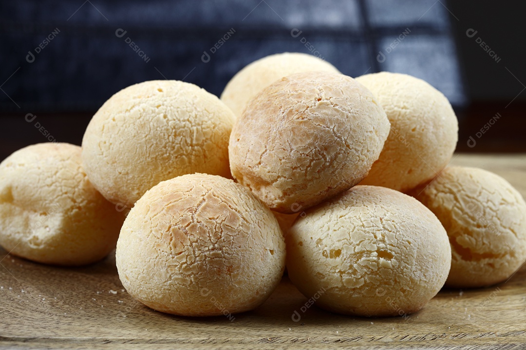 Pães de queijo sobre uma tábua de madeira