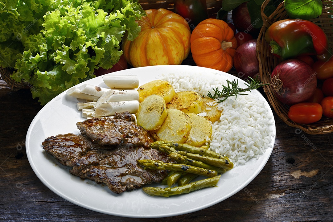 Arroz com batata e carne em um prato sobre mesa de madeira