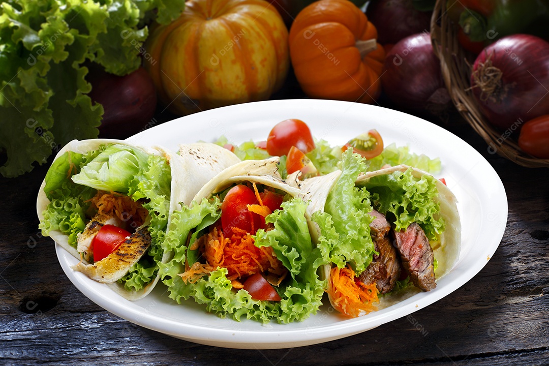 Enrolar de salada em uma prato sobre mesa de madeira