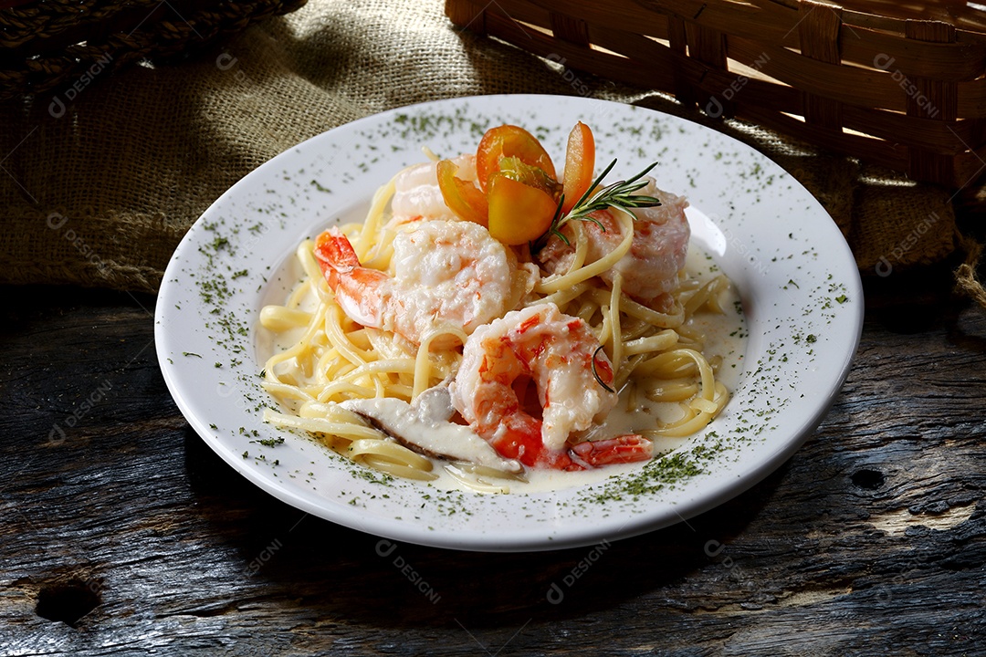 Camarão grande com macarrão em prato sobre mesa de madeira