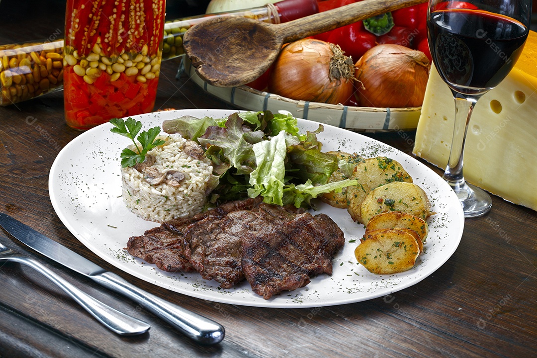 Arroz com batata e carne em um prato sobre mesa de madeira