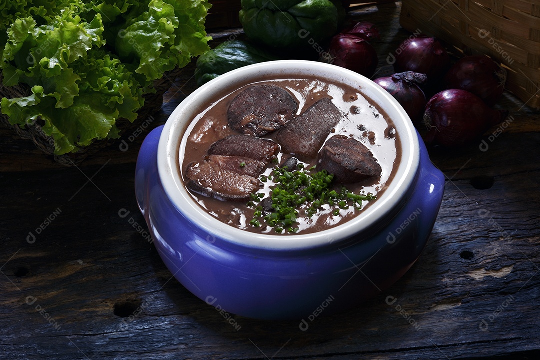 Feijoada em tijela sobre mesa de madeira