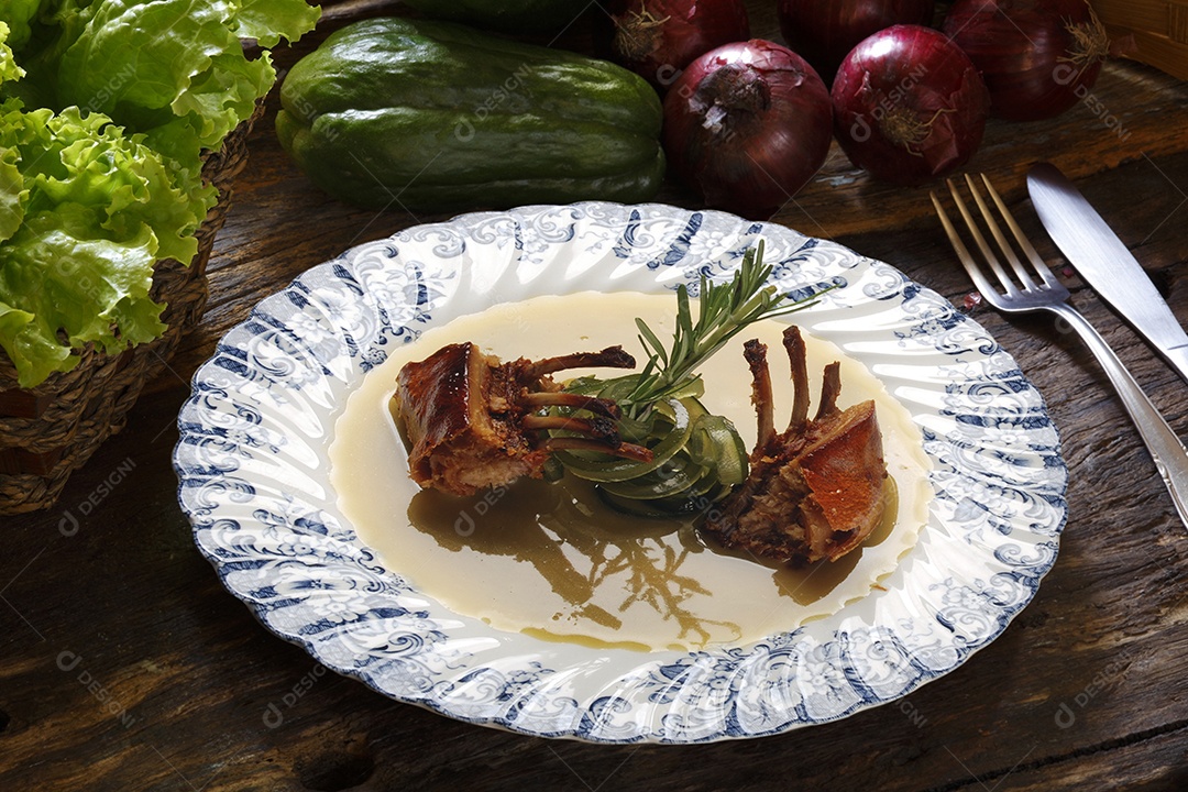Carré de Cordeiro em um prato sobre mesa de madeira