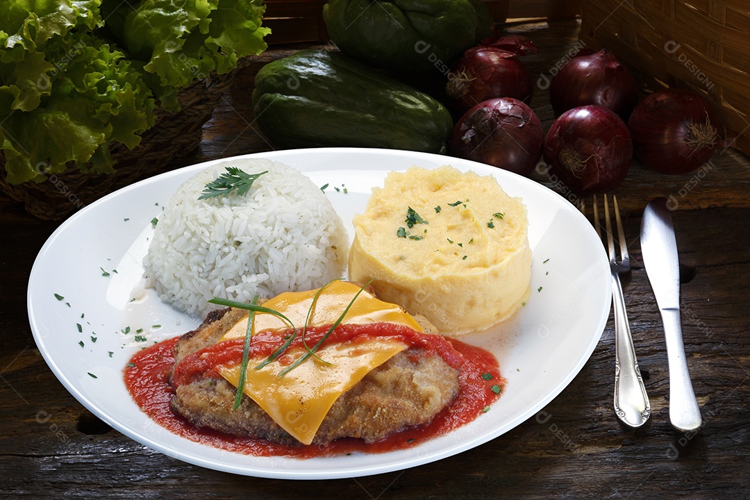 O bife à parmegiana com  arroz em um prato sobre fundo isolado