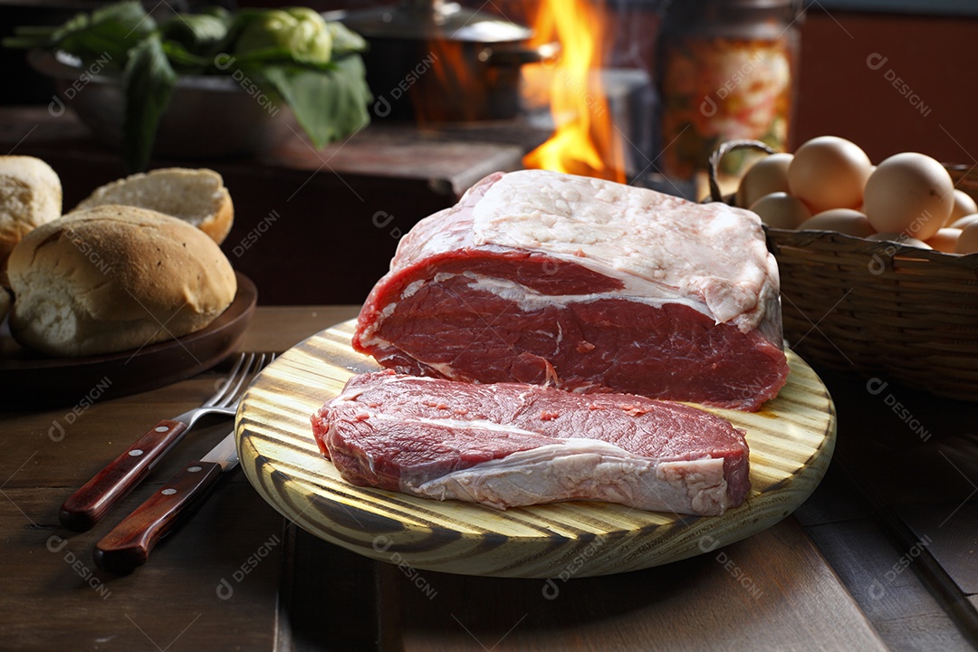 Bife cru em tábua sobre mesa de madeira