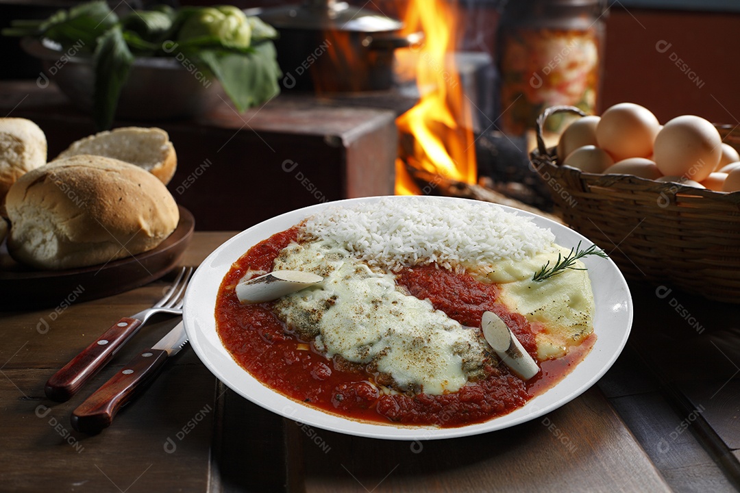 O bife à parmegiana com batata e arroz em um prato sobre fundo isolado