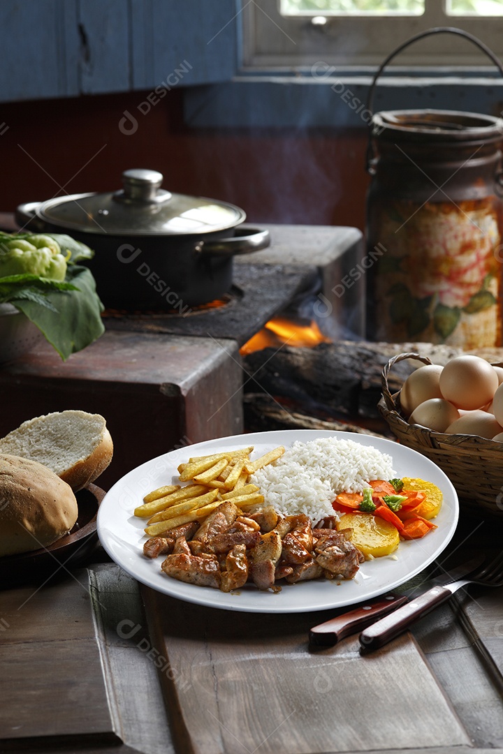 Bife grelhado com batata e arroz em um prato sobre mesa de madeira