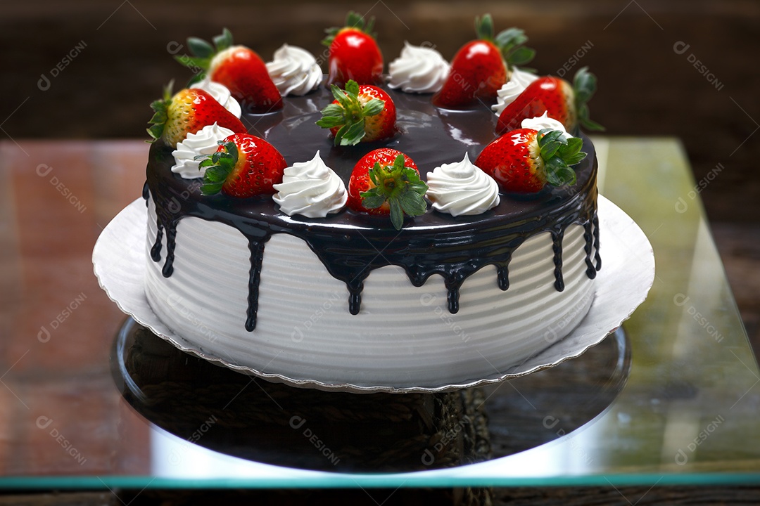 Bolo de chantilly com morango em prato sobre mesa de madeira