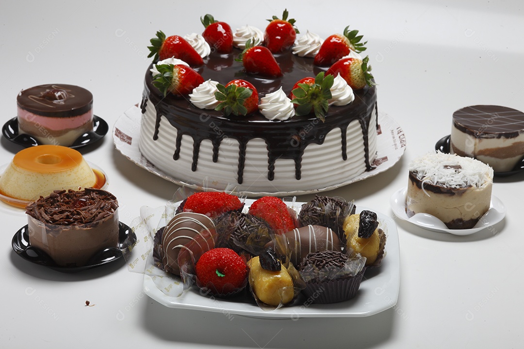 Mesa com bolos e varios doces de sobremesa