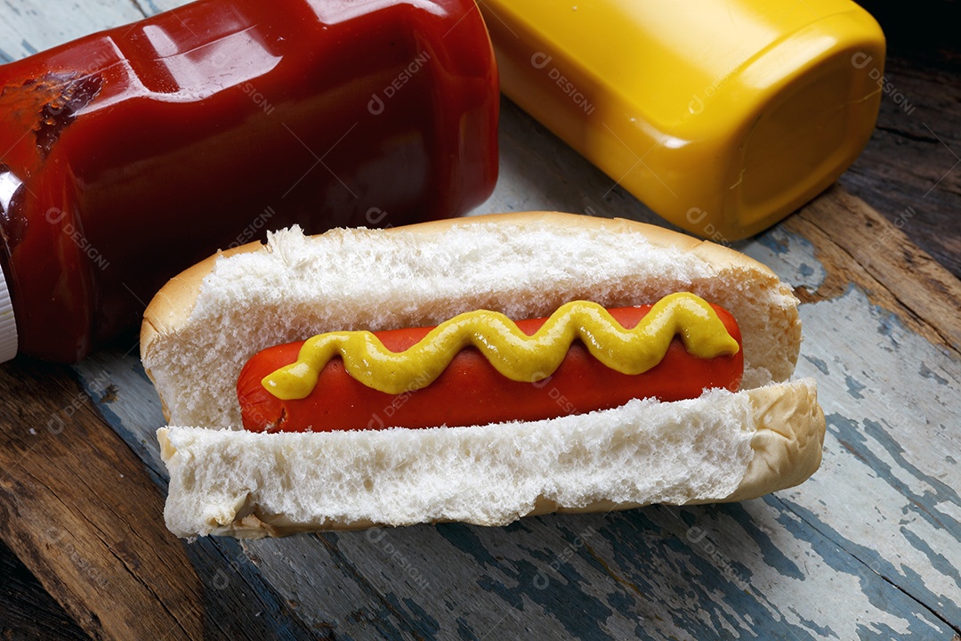 Tábua de madeira com cachorro quente e molhos delicioso