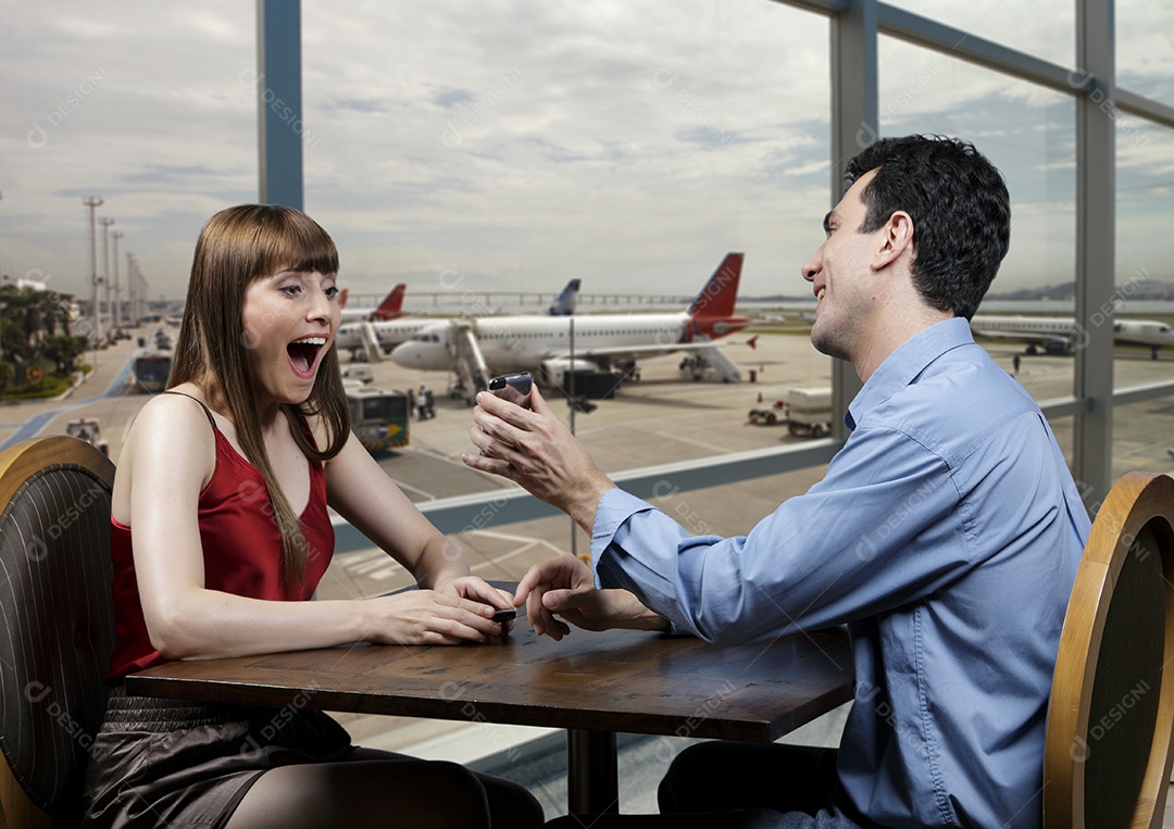 Casal feliz comemorando em um restaurante de aeroporto