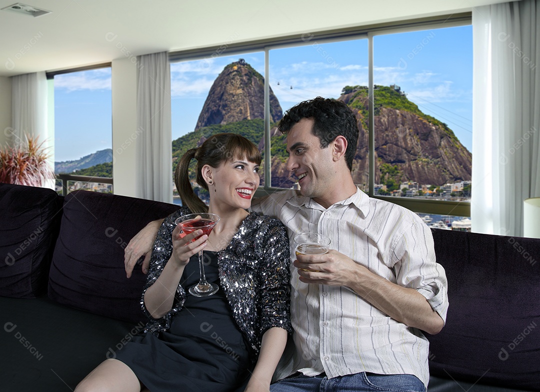 Um casal com drinks nas mãos e felizes