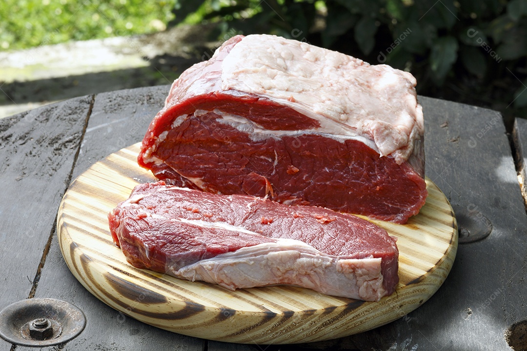 Carne fatiada sobre tábua de madeira