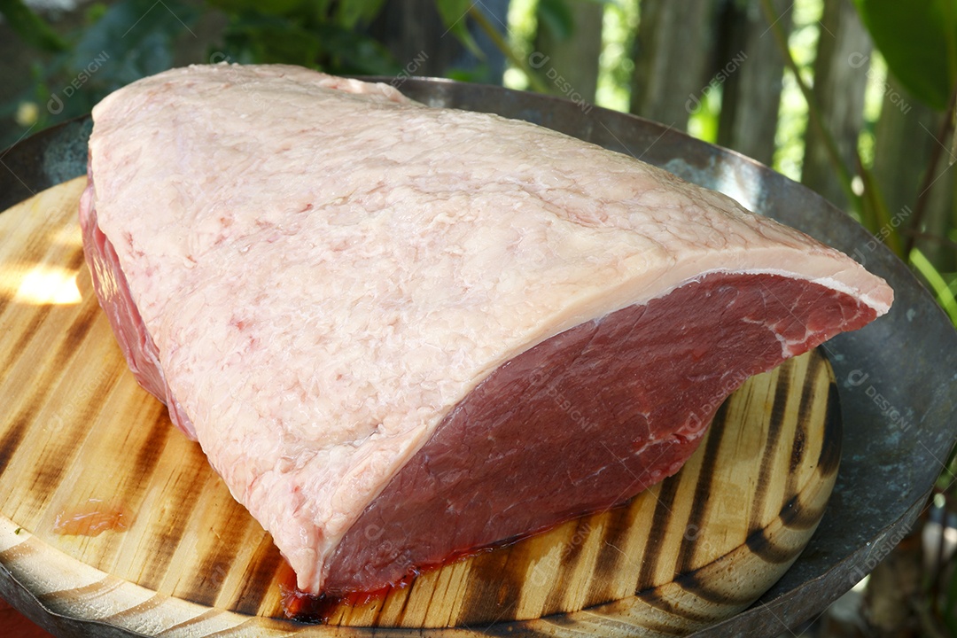 Peça de picanha crua sobre tábua de madeira