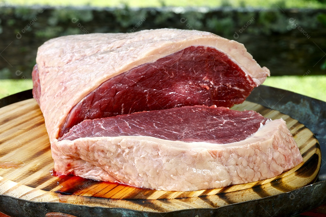 Peça de picanha para churraco sobre uma tábua de madeira