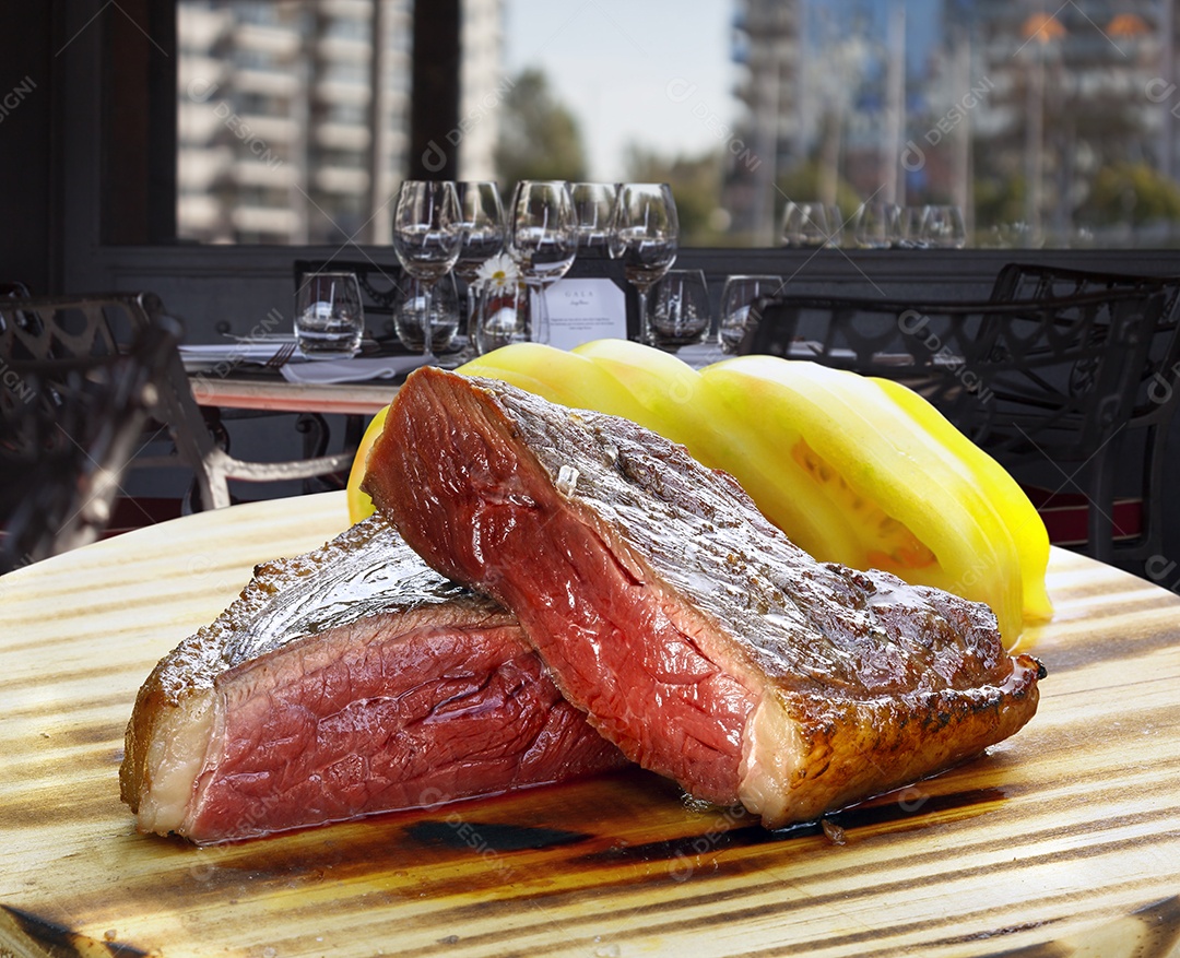 Carne mal passada com tomates sobre uma tábua