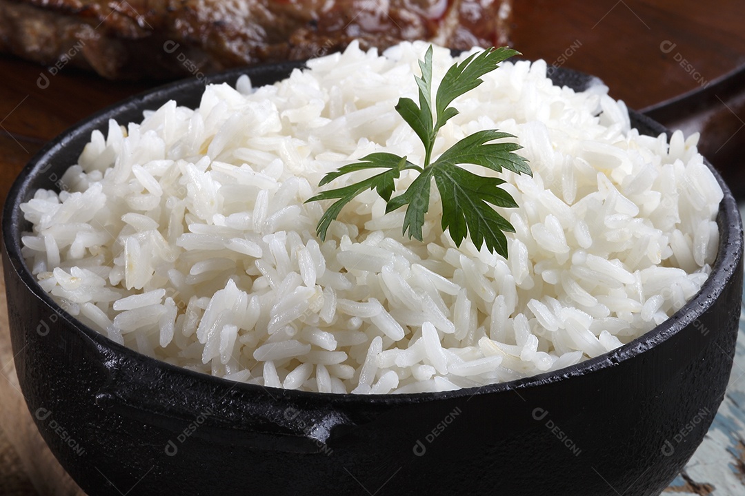 Uma porção de arroz cozido em tigela preta
