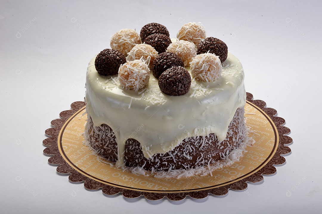 Delicioso bolo de chocolate com cobertura branca e brigadeiros encima