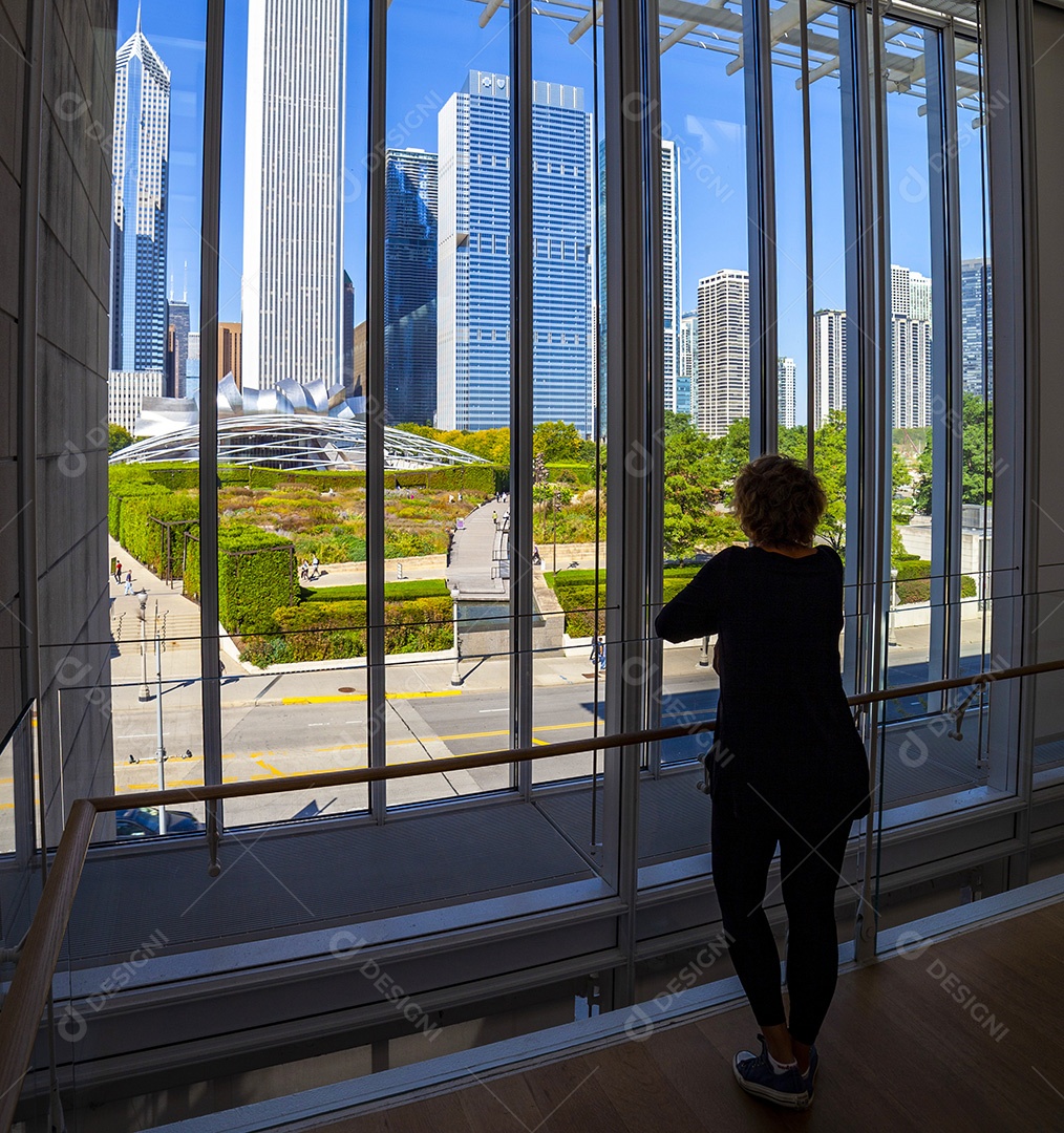Mulher olhando pela janela arranha céus no centro de Chicago
