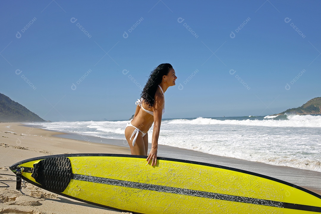 Mulher se preparando para surfar no Rio de Janeiro