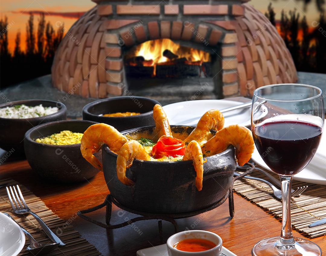 Moqueca de camarão com taça de vinho tinto